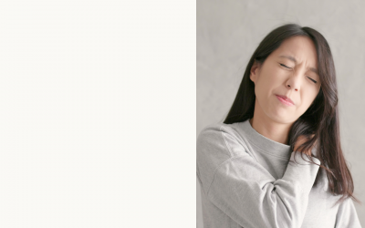 Woman in pyjamas holds her painful shoulder as she struggles to sleep.