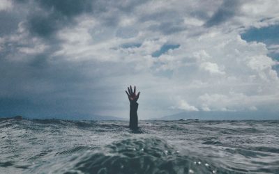 Image shows an arm raising up above the water surface.