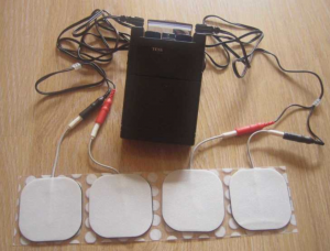 Image shows a TENS machine with four electrode pads.